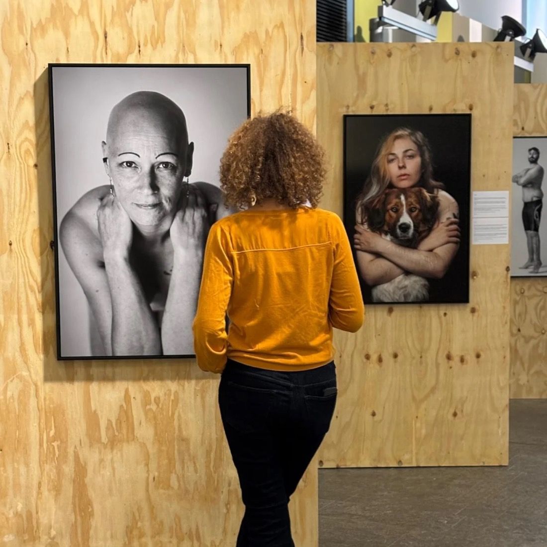 Visiteuse regardant les portraits exposés à Tour & Taxis