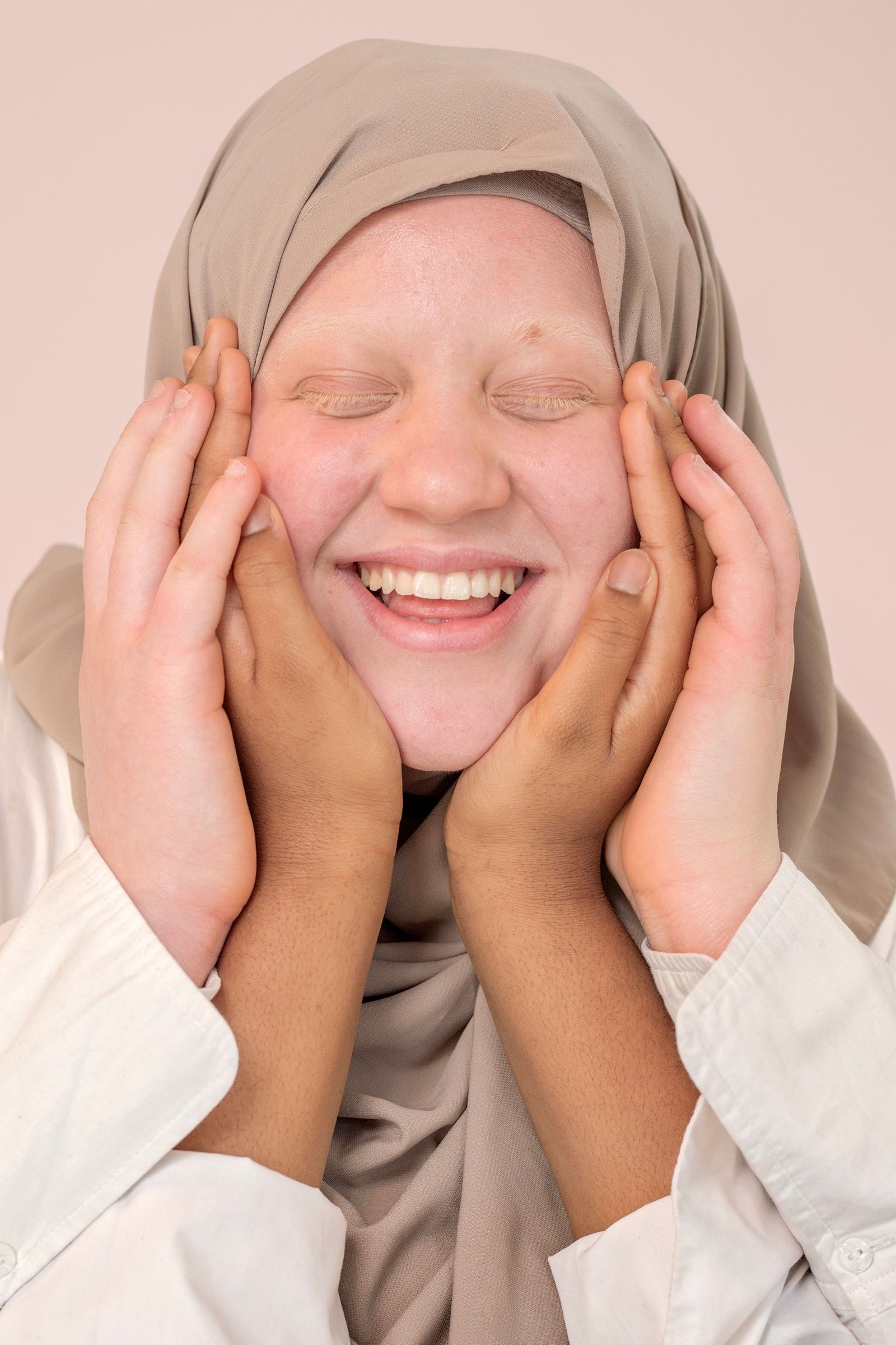 Portrait exposé de Hadja, les mains sur le visage