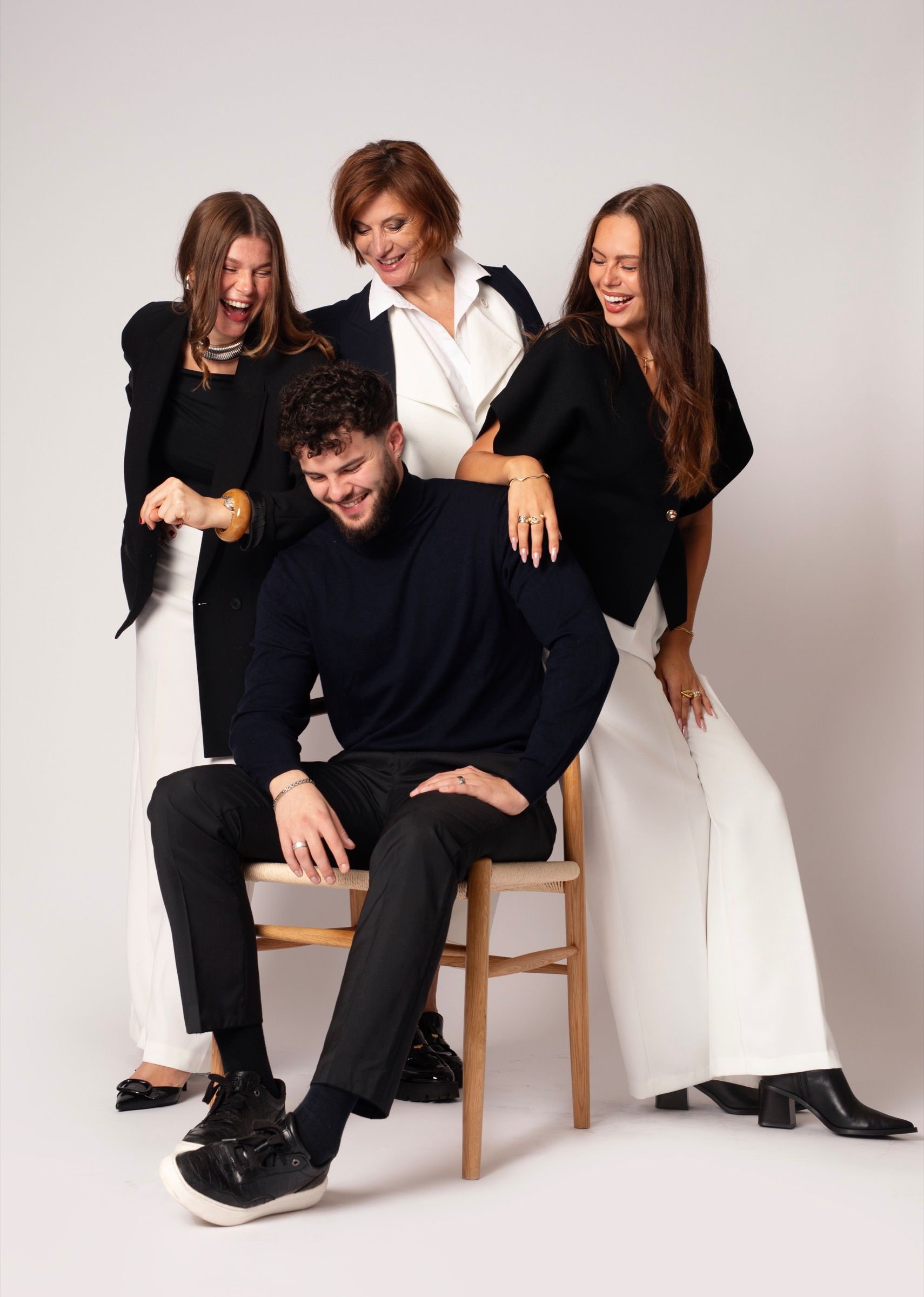 Portrait de famille en studio, quatre adultes riant ensemble