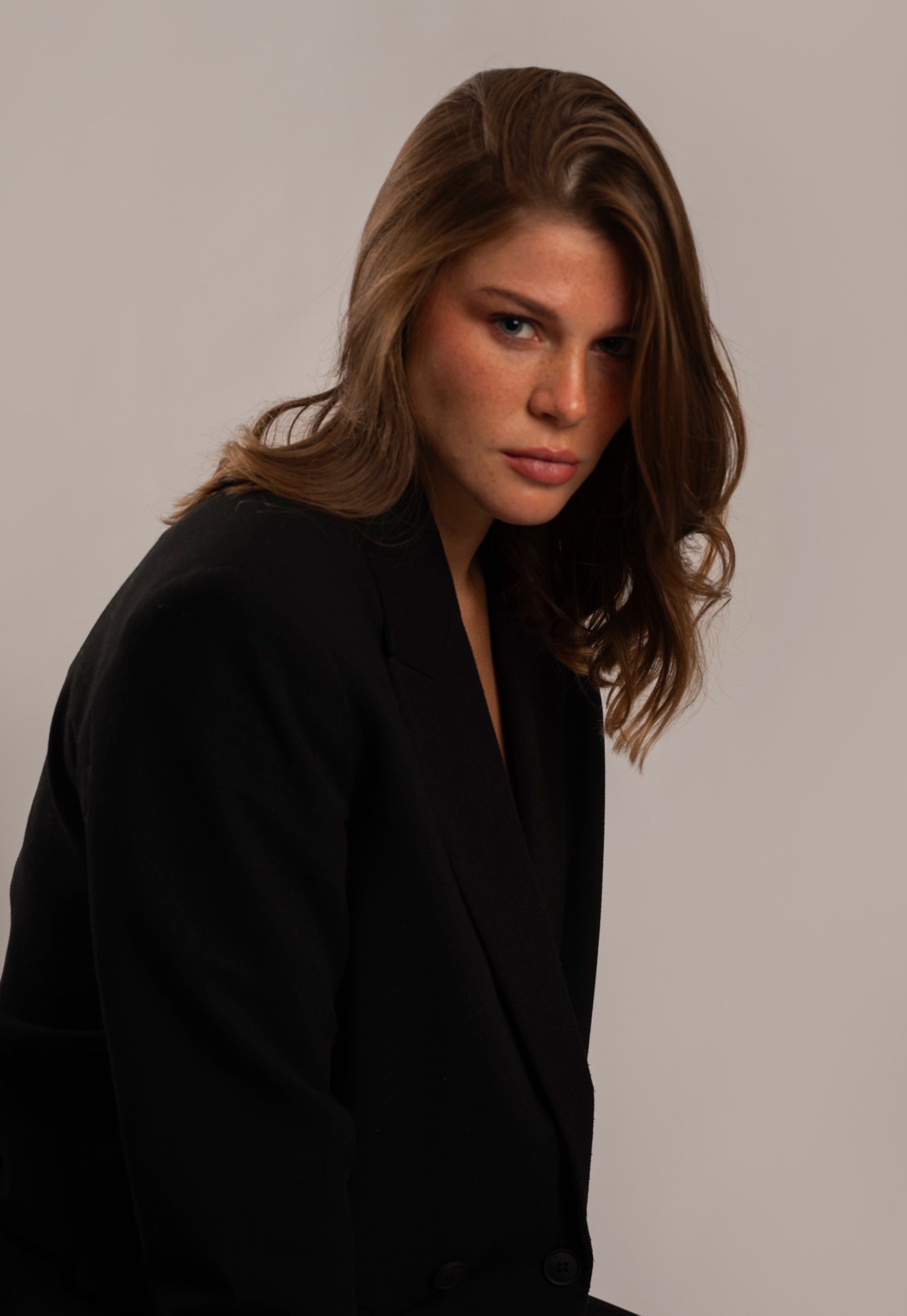 Portrait studio d'une jeune femme en veste noire, regard direct, photographe portraitiste