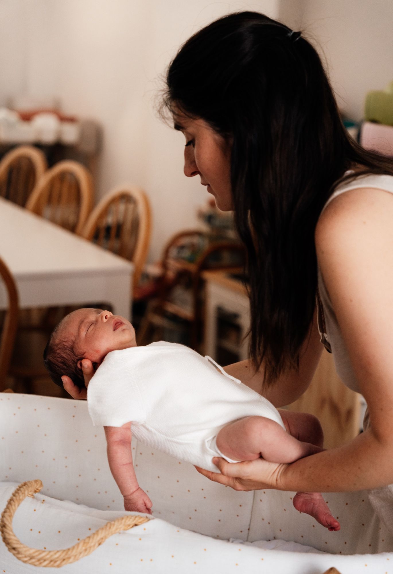 Mother holding her sleeping newborn against her, warm light in the studio (10)